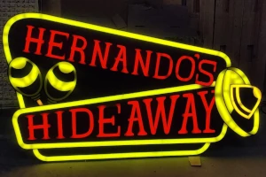 Festive yellow and red glowing sign for Hernando's Hideway