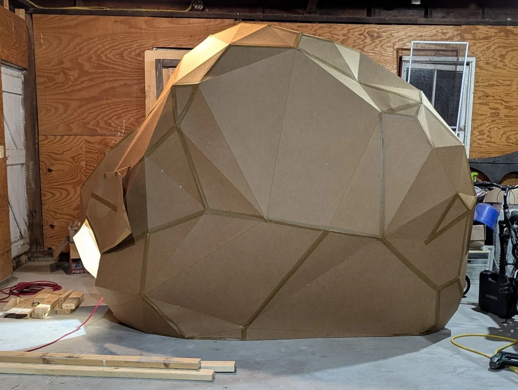 An eight-foot-tall rock made of cardboard, held together with tape and hope.